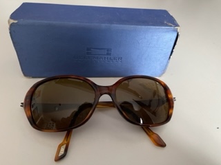 Eine Sonnenbrille liegt vor einem blauen Etui.