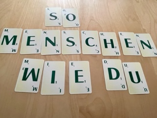 In Scrabble-Buchstaben ist der Schriftzug "So Menschen wie du" zu lesen.